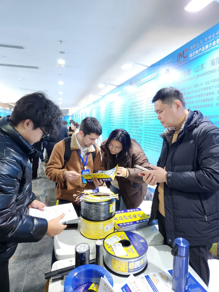 "Conversación comercial en la feria de Linyi, donde Habaki explora alianzas y oportunidades de exportación en el mercado internacional."